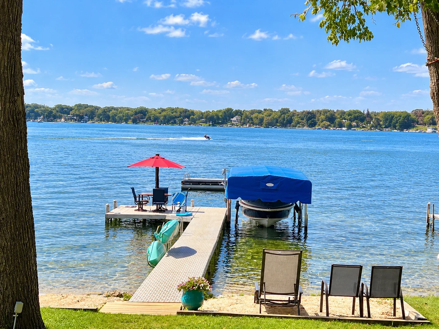 Dock, boat lift, and beach seating on Powers Lake